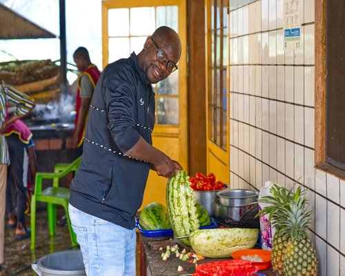 man preparing healthy vegetable salad in kitchen